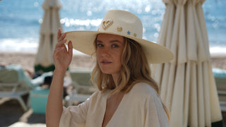 El Sombrero Panamá Charlotte es una pieza diseñada para destacar. Su ala ancha y su silueta estructurada crean una presencia sofisticada y muy favorecedora, mientras que los delicados apliques dorados aportan un toque distintivo que eleva cualquier look con naturalidad.