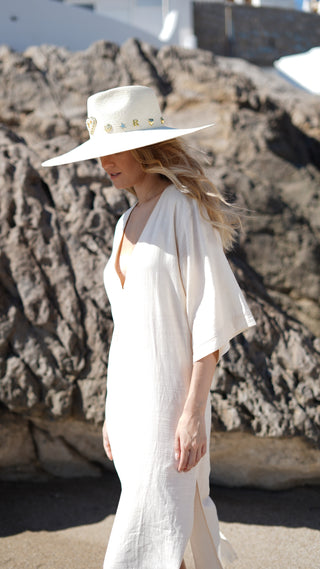 El Sombrero Panamá Charlotte es una pieza diseñada para destacar. Su ala ancha y su silueta estructurada crean una presencia sofisticada y muy favorecedora, mientras que los delicados apliques dorados aportan un toque distintivo que eleva cualquier look con naturalidad.